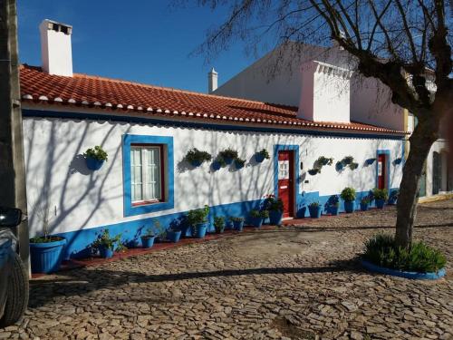 a white and blue building with a red door at Casa dos Pécoxinhos in Arcos