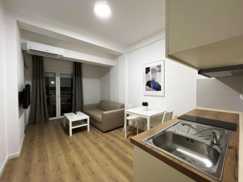 een keuken en een woonkamer met een wastafel en een bank bij Lumi Apartments in Gevgelija