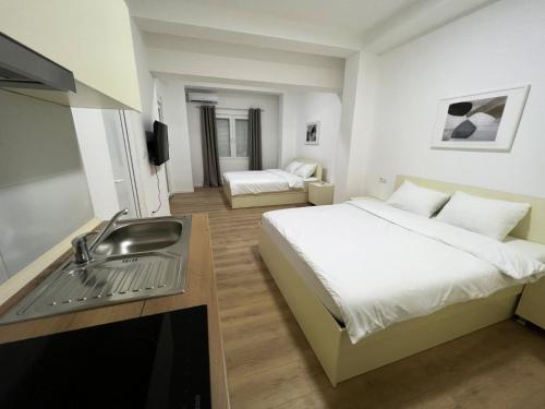 een hotelkamer met een bed en een wastafel bij Lumi Apartments in Gevgelija