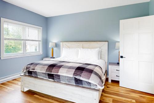 1 dormitorio con paredes azules y 1 cama con cabecero de madera en Spruce, en Bethel