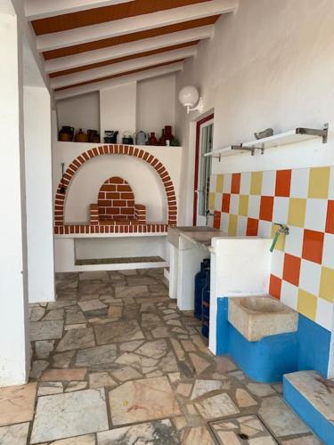 a kitchen with a stone floor and a brick oven at Casa dos Pécoxinhos in Arcos