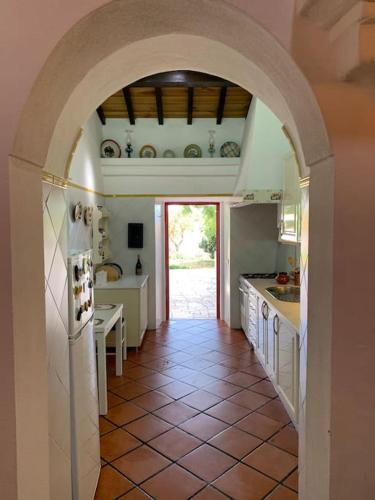 a large kitchen with an archway in a house at Casa dos Pécoxinhos in Arcos