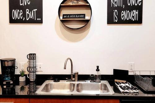 a kitchen counter with a sink and a mirror at Staycation City Loft Free Gated Parking in Saint Louis
