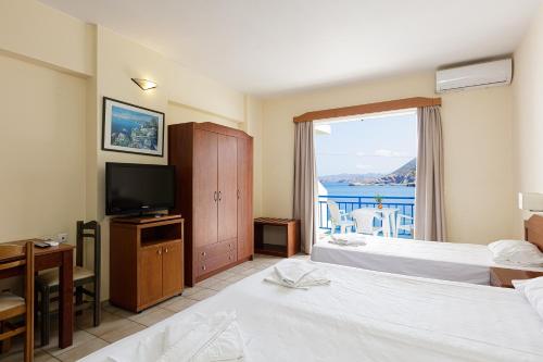 ein Hotelzimmer mit 2 Betten und einem TV in der Unterkunft Bali Beach and Sofia Village in Balíon