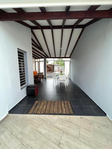 un soggiorno con pavimento piastrellato nero e soffitto di NOTRE MAISON a Sainte-Anne