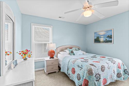 a blue bedroom with a bed and a ceiling fan at Blue View in Holden Beach