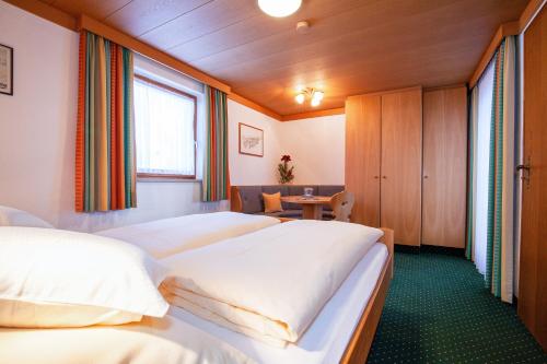 a hotel room with three beds and a table at Alpenblick in Reit im Winkl