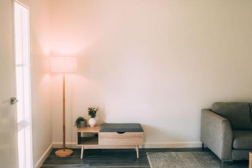 a living room with a chair and a lamp at The Vine House - Benalla in Benalla