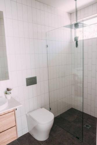 a bathroom with a toilet and a glass shower at The Vine House - Benalla in Benalla