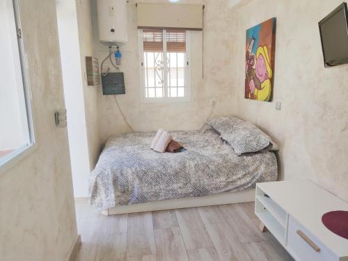 - une petite chambre avec un lit et une fenêtre dans l'établissement Lolas Cozy Studio, à Grenade