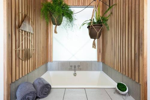 uma banheira numa casa de banho com duas plantas em ChampaHouse- Easy access to Rino/Ballpark/Downtown em Denver