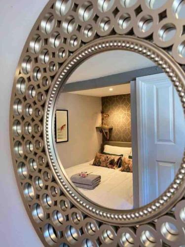a mirror reflecting a bedroom with a bed in it at Jane's Pad in Bournemouth
