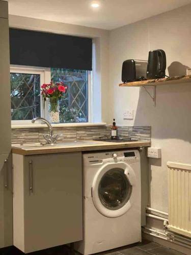 a kitchen with a washing machine under a counter at Jane's Pad in Bournemouth