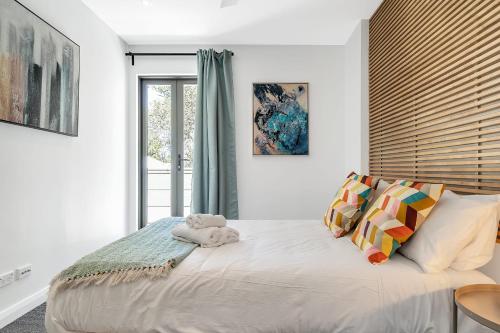 a bedroom with a large bed with a window at Eclectic Perfectly Positioned Apartment in Sydney