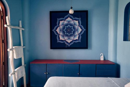 a blue room with a red table and a picture at Casa Love in Sayulita