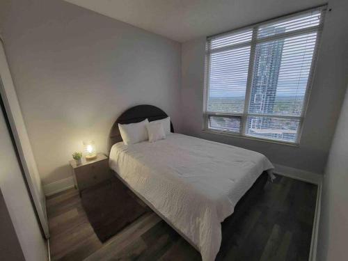 - une petite chambre avec un lit et une fenêtre dans l'établissement City Centre Lodge ( Downtown), à Mississauga