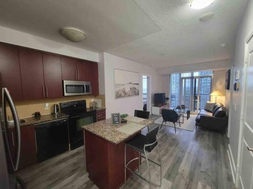 a kitchen and living room with a table and a counter at City Centre Lodge ( Downtown) in Mississauga