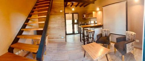 Habitación con escalera, mesa y sillas en Loft Girasoles Vla en Villa La Angostura