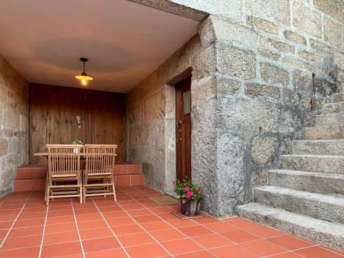 a patio with two chairs and a table and stairs at São Jorge Country House in Penafiel