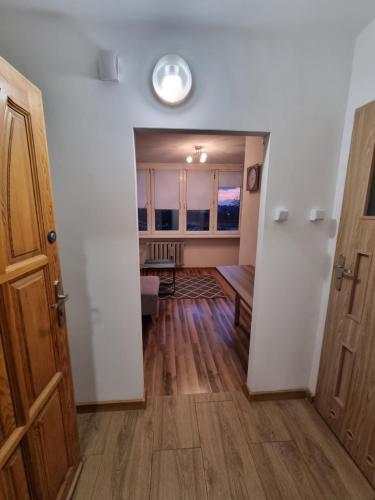 Zimmer mit einem Flur mit einer Tür und einem Tisch in der Unterkunft Apartament 41 in Częstochowa