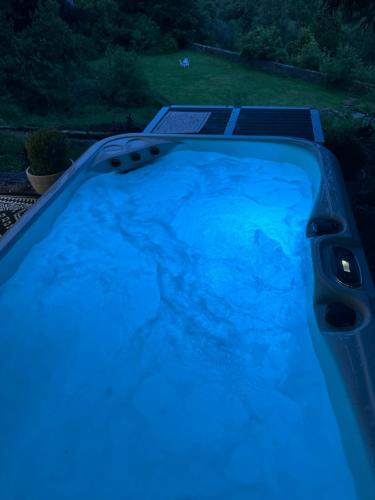 a blue hot tub in a yard at night at Unique Orchard Lodge for couples with hot tub in Strathaven