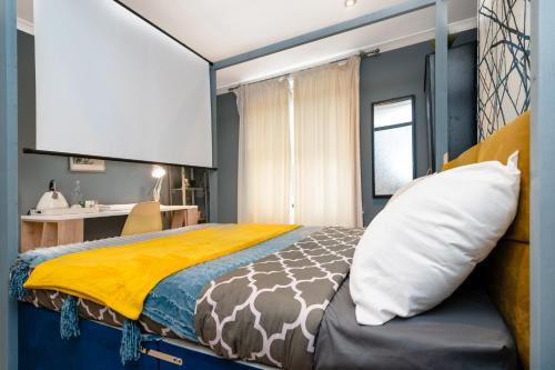 a bedroom with a large bed with a yellow blanket at Double Room with TV and Garden Hot Tub in London