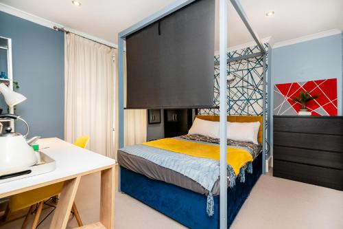 a bedroom with a canopy bed with a desk at Double room w/Projector & Garden Hot Tub in London