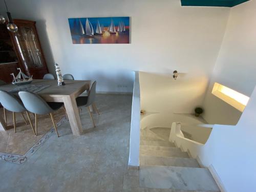 une salle à manger avec une table, des chaises et un escalier dans l'établissement Moradia Olival- BBQ, 2 Quartos, Quintal, à Albufeira