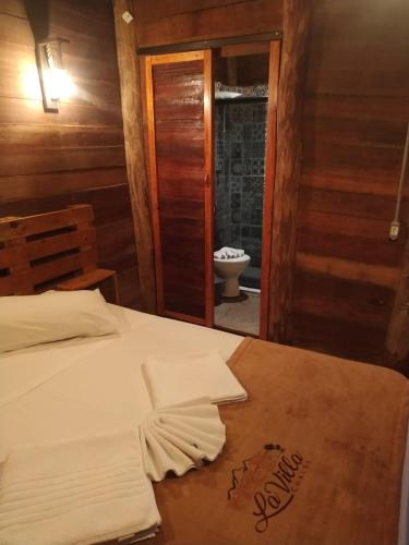 a bedroom with a bed with towels on it at La Villa Chalés Garden in Serra Negra