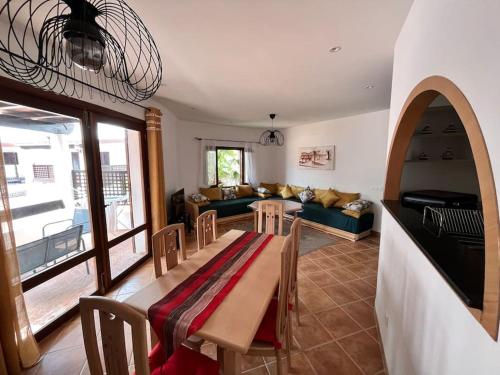 Appart magnifique Cabo Negro في كابو نيغرو: غرفة معيشة مع طاولة وأريكة