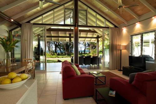 a living room with red couches and a table at 2/24 Donkin - Luxury - Absolute Beachfront in Mission Beach