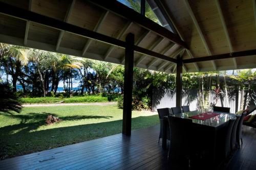 a porch with a table and chairs on a deck at 2/24 Donkin - Luxury - Absolute Beachfront in Mission Beach