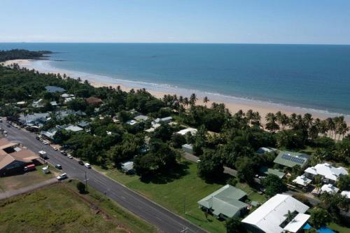 an aerial view of a beach with houses and a road at 2/24 Donkin - Luxury - Absolute Beachfront in Mission Beach