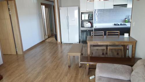 a living room with a table and a kitchen at Geoje Seaside Two floors Villa in Geoje 