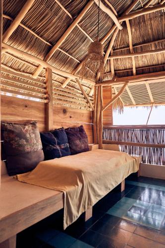 a bed in a room with a wooden ceiling at Casa Love in Sayulita