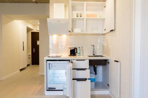 a small kitchen with white cabinets and a sink at The SPOT apartments - Orbi Beach Tower in Batumi