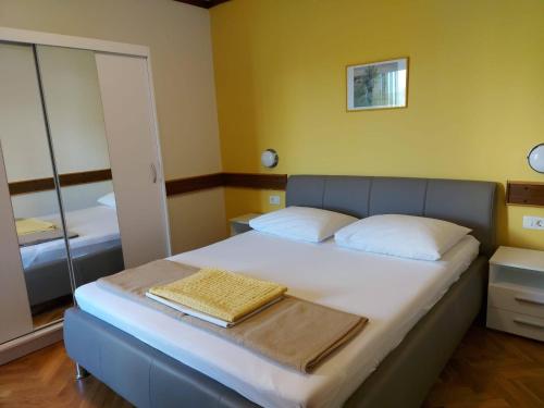 um quarto com uma cama com uma toalha em Apartments by the sea Palit, Rab - 15794 em Rab