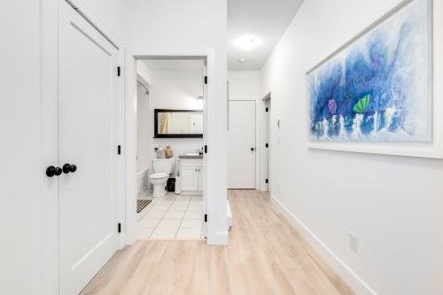 a hallway with white walls and a painting on the wall at Crescent Beach is a walk away from Casa Altamira! in Surrey