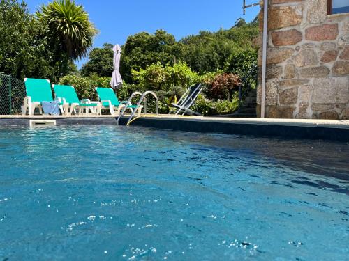 een zwembad met stoelen en een zwembad bij Casa da Lage - Lindas vistas - Gerês - Rio - Campo in Geres