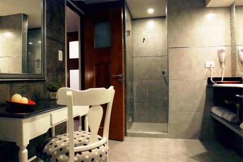 a bathroom with a shower and a white chair at Turismo Hotel Casino in Corrientes