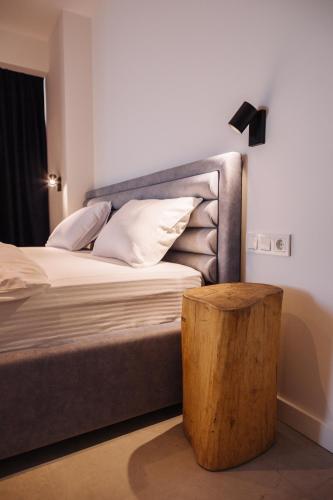 a bed with a gray headboard and a wooden table at The SPOT apartments - Orbi Beach Tower in Batumi
