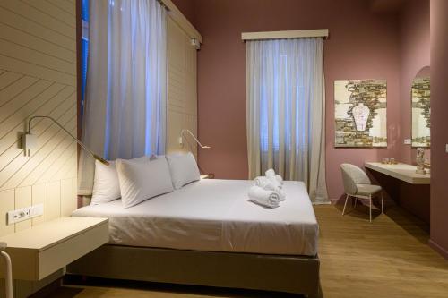 a bedroom with a bed and a bathroom with a sink at BlueBlood - The Rooms in Kalamata
