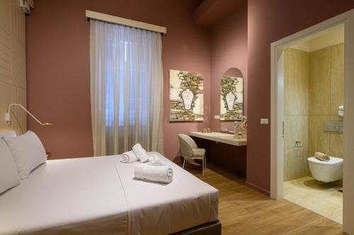 a bedroom with a bed and a bathroom with a sink at BlueBlood - The Rooms in Kalamata