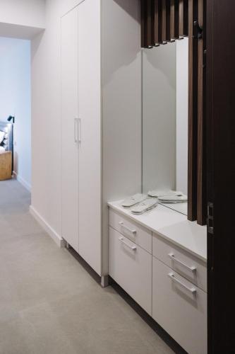 a white bathroom with white cabinets and a mirror at The SPOT apartments - Orbi Beach Tower in Batumi