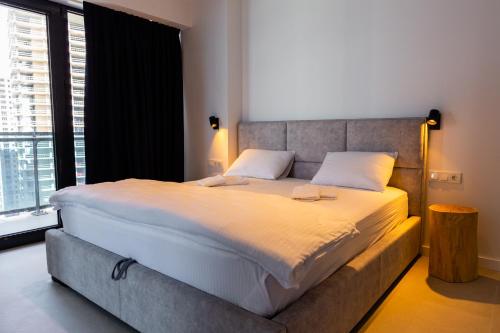 a bedroom with a large bed with a large window at The SPOT apartments - Orbi Beach Tower in Batumi