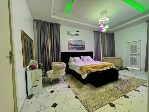 a bedroom with a bed and a chair at Deluxe Dream Apartment in Lekki