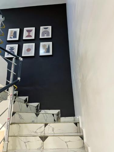 a staircase with pictures on a black wall and a stair case at Deluxe Dream Apartment in Lekki