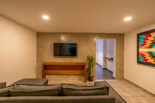 a living room with a couch and a flat screen tv at Casa Madero La Paz in La Paz