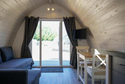 a living room with a couch and a table with a tv at King's Lynn Caravan & Camping Park in King's Lynn