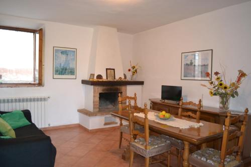 a living room with a table and a fireplace at Appartamento La Chiusa in Monticiano